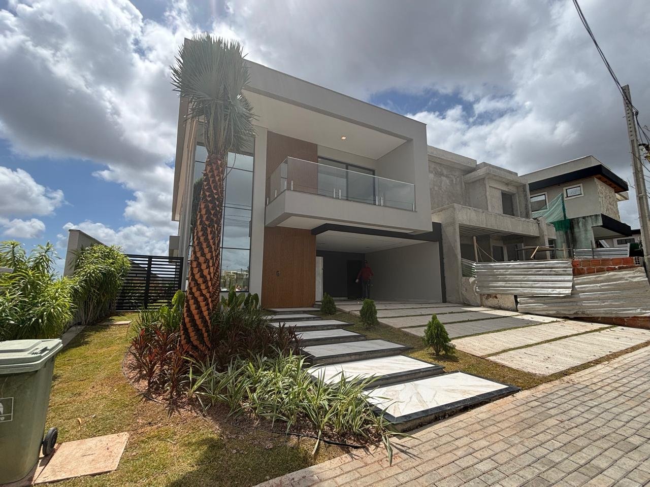 Casa contemporânea com varanda, jardim e fachada de pé-direito duplo